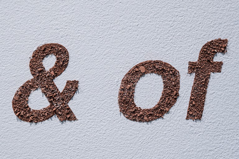 Signage in nori paste (same material that will be deposit with the robot) + crushed rocks.| Photo by Alexis Bellavance Signage saying, "& of"